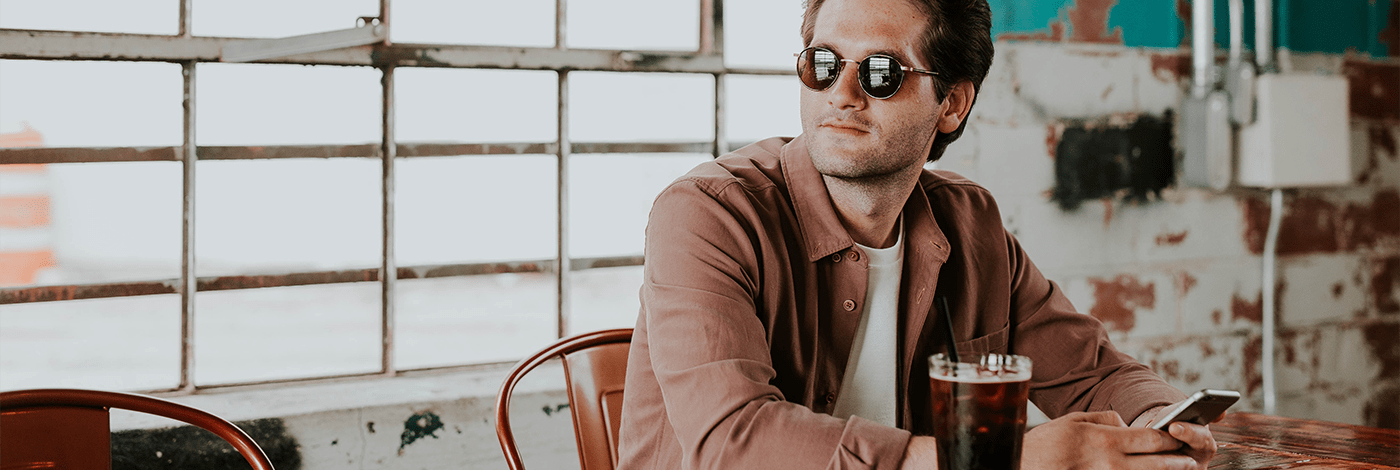 Mann mit einem Smartphone am Tisch